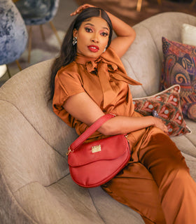 Denri Africa's red Montana Sling Bag. Fashionable red sling purse, modern vegan leather, small daily carry bag.