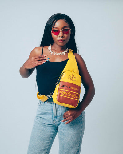Denri Africa’s yellow Denri x Manyatta Crossbody Bag. Bright vegan-leather crossbody sling, slim profile bag, stylish statement carry.